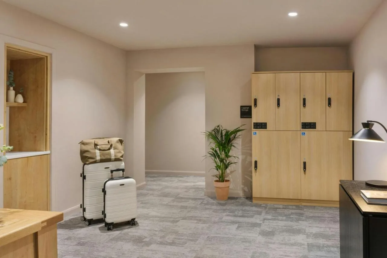 a room with a chair and a suitcase in a room at VCity Suites at The Teacher in Glasgow
