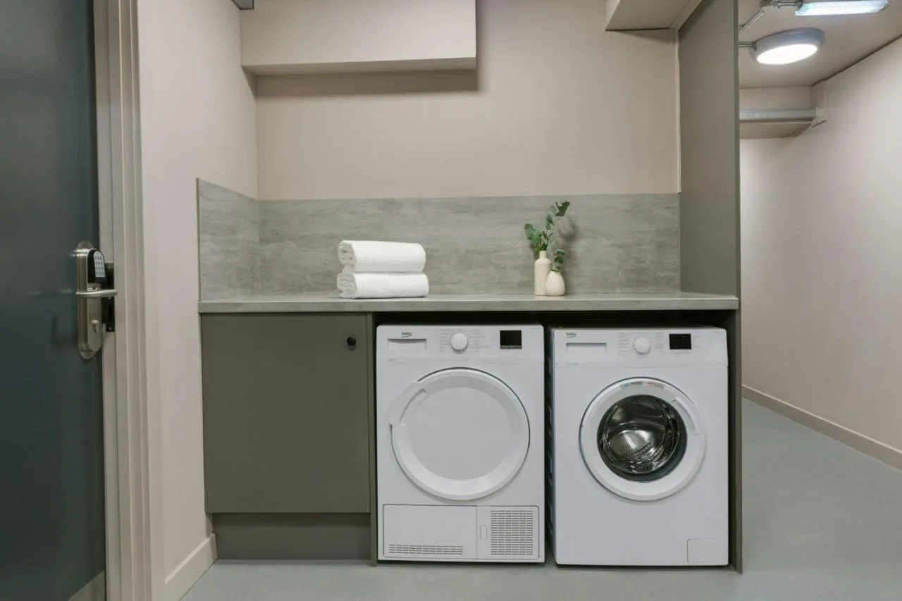 a laundry room with a washer and dryer at VCity Suites at The Teacher in Glasgow