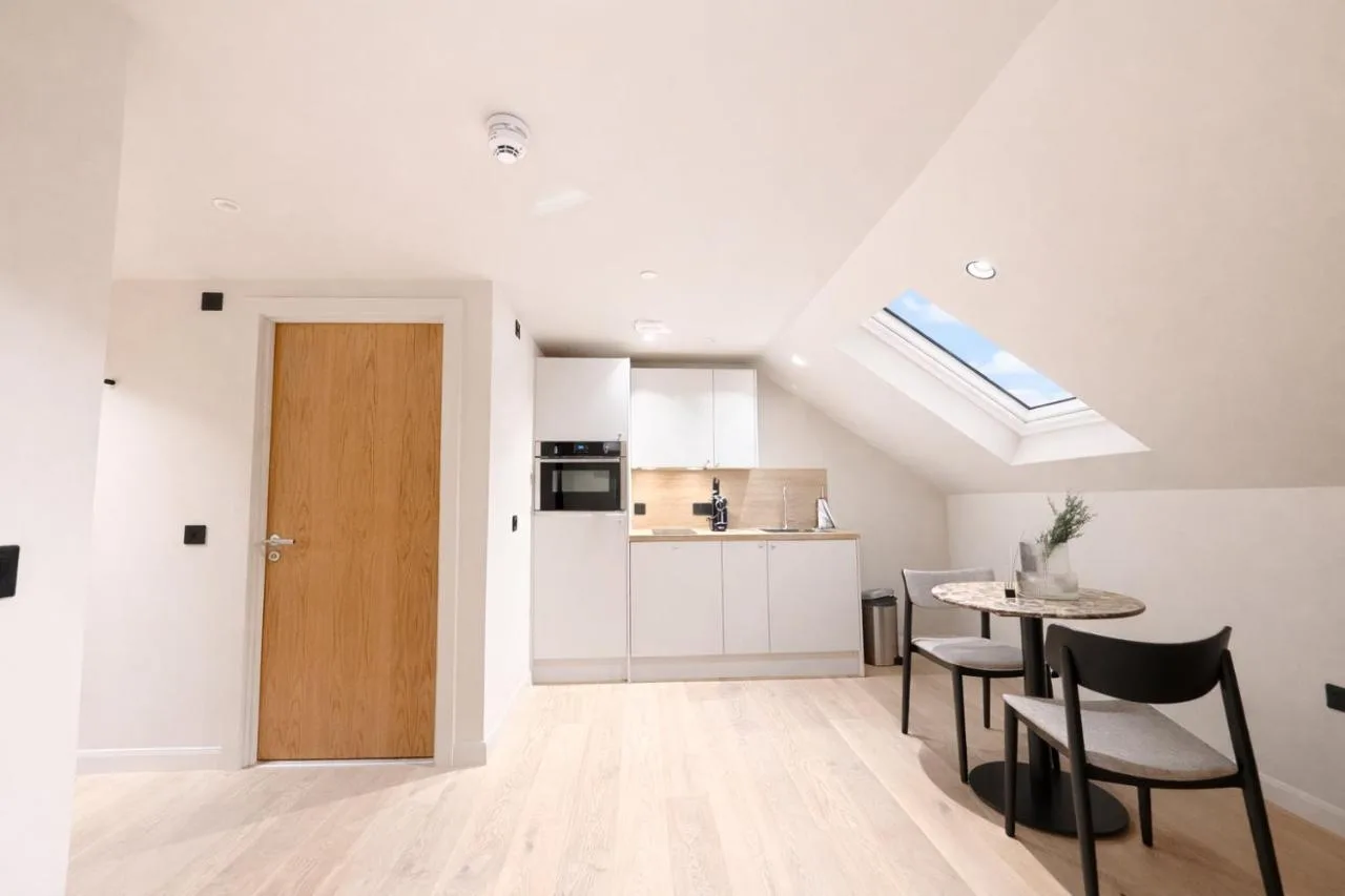 a kitchen and dining room with a door and a table at VCity Suites at The Teacher in Glasgow